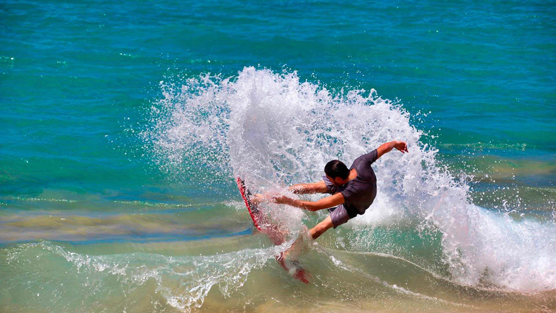 Galapagos-Surfer fangen eine Welle auf der Insel San Cristobal
