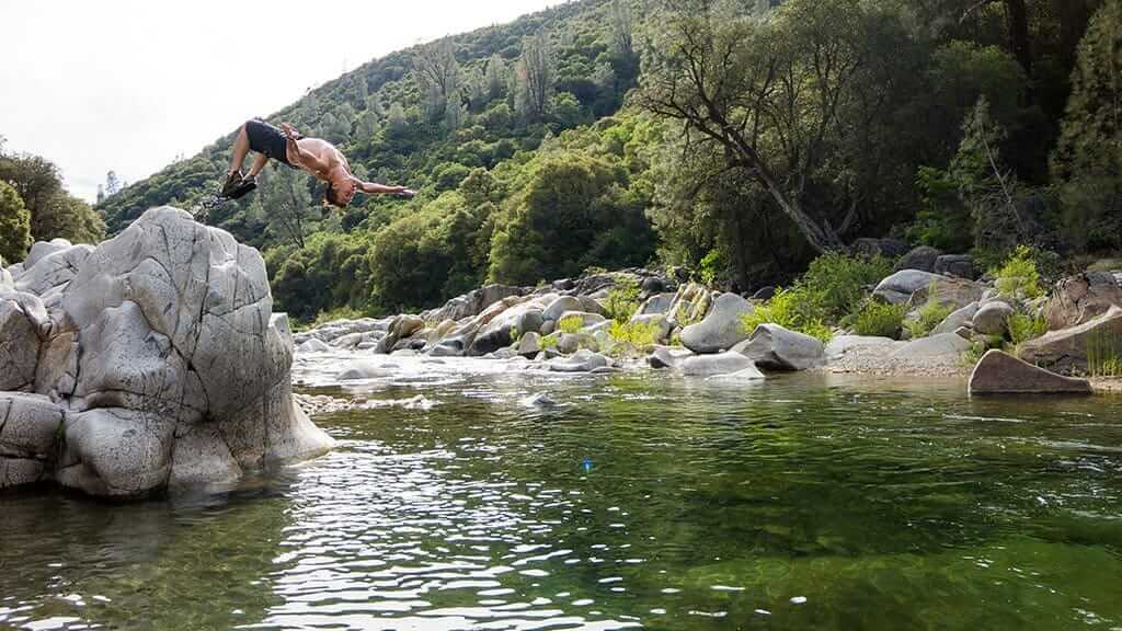 tourist does a backflip dive into a jungle river in ecuador