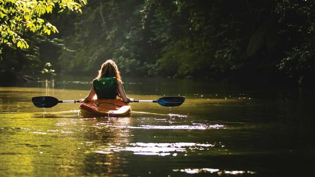 Una niña se desplaza lentamente río abajo en un kayak - Selva Amazónica de Ecuador