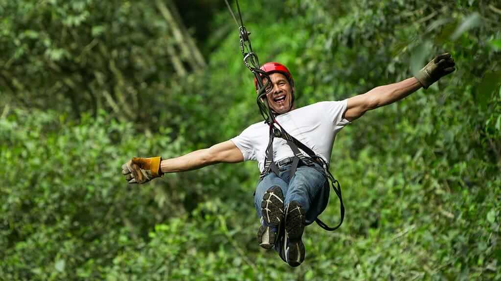 happy tourist enjoying canopy ziplining tour in Mindo cloudforest , Ecuador