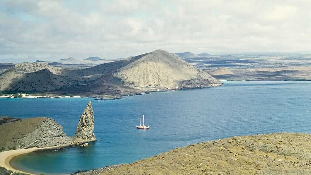 Eine kleine Yacht, die vor Pinnacle Rock auf der Bartolome-Insel Galapagos vor Anker liegt