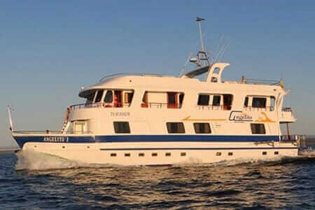 Angelito Yacht Galapagos Kreuzfahrt - Die Angelito beleuchtet von goldenem Licht bei Sonnenuntergang