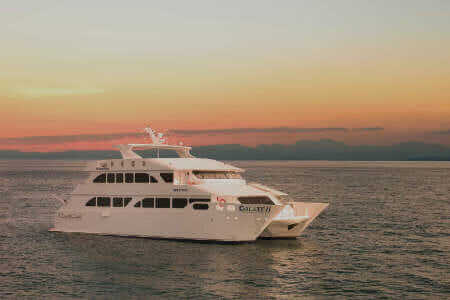 ecogalaxy catamaran galapagos cruise - side view of ecogalaxy II yacht at sunset