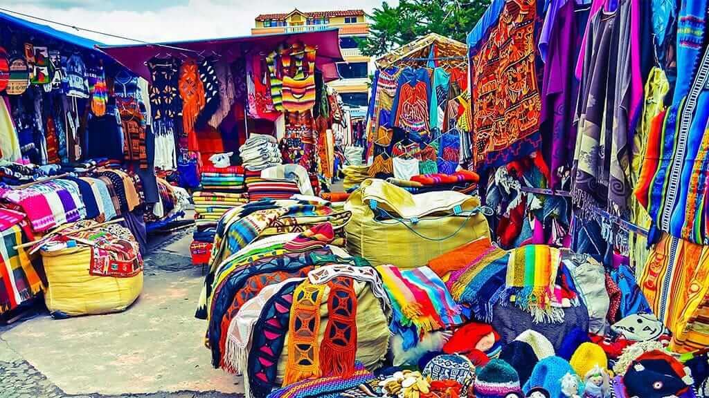 Coloridos puestos de mercado en el mercado de artesanías de Otavalo Ecuador