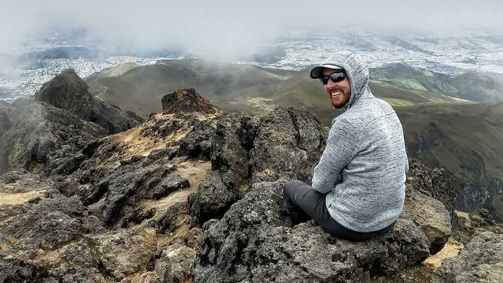 glücklicher Tourist auf dem Gipfel des Vulkans Rucu Pichincha - ein einfacher Tagesausflug von Quito