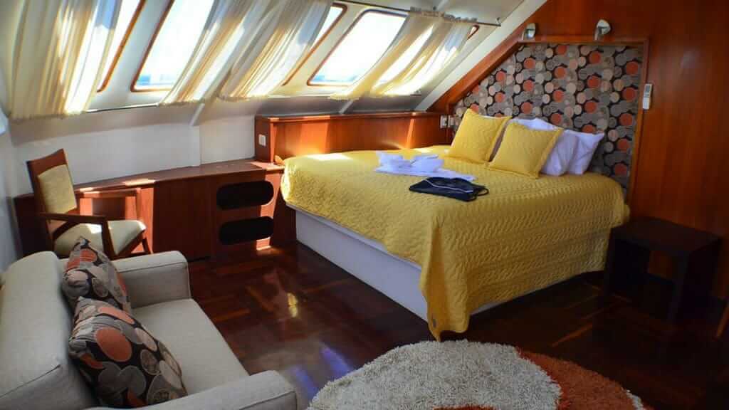 Crucero por Galápagos en yate en catamarán Anahi - interior de cabina doble para invitados con sofá