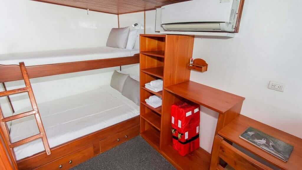 Crucero Aqua Yacht Galápagos - camarote de invitados con litera con cama doble inferior y espacio superior y de almacenamiento individual