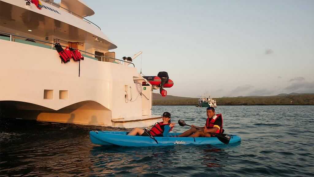 tourists enjoy sea kayaking on the EcoGalaxy II cruise at Galapagos Islands
