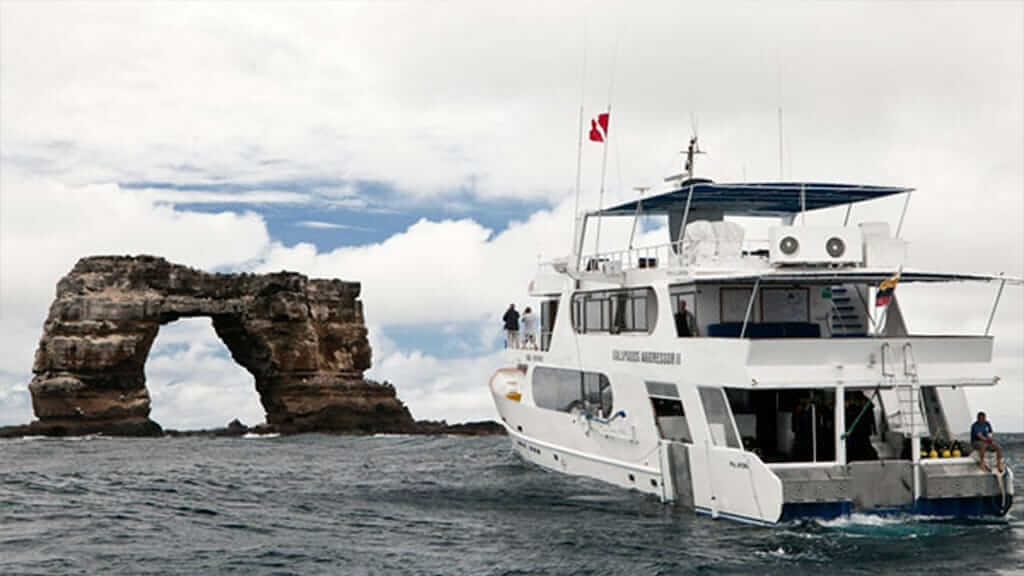 Yate de buceo Aggressor III crucero Galápagos - vista trasera del yate Aggressor acercándose al Arco Darwins