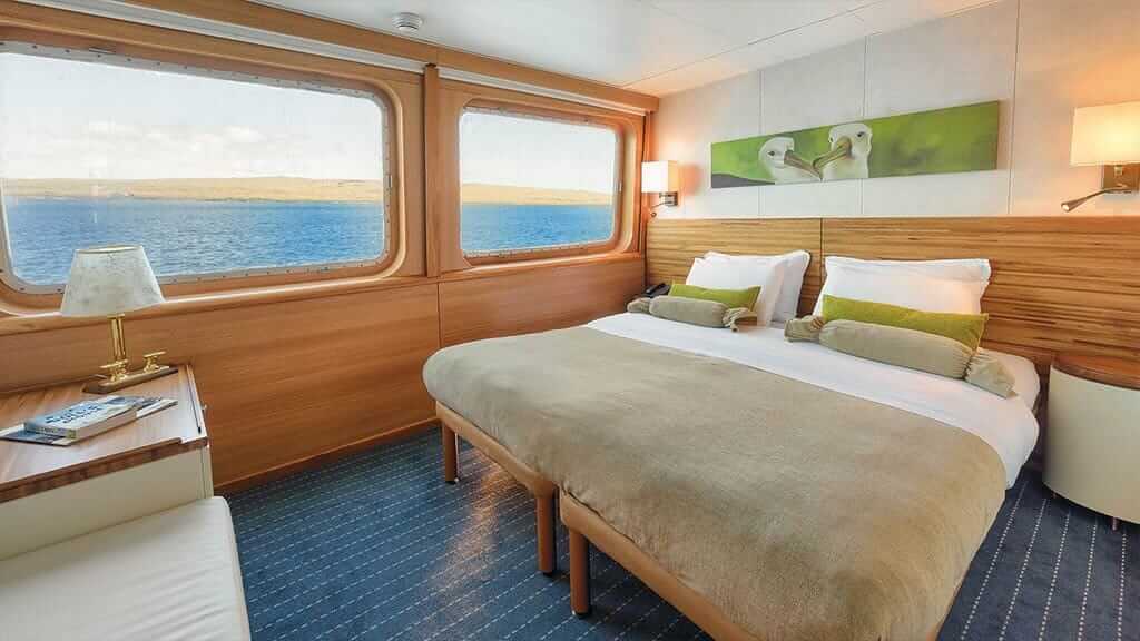 Legendäres Kreuzfahrtschiff Galapagos-Inseln - normale Suite mit Kingsize-Bett und großen Fenstern