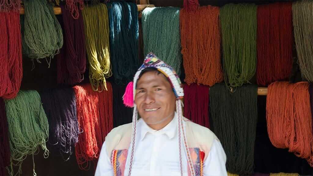 Indiase weversman met gekleurde wol in de saacred-vallei van Peru