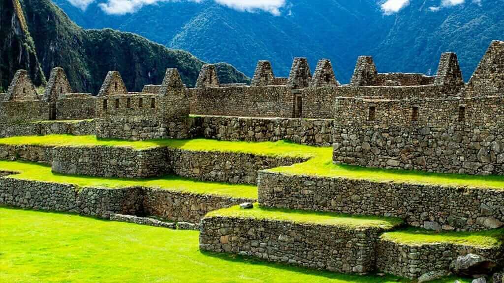 grüne Terrassen und Steinhäuser in Machu Picchu Peru