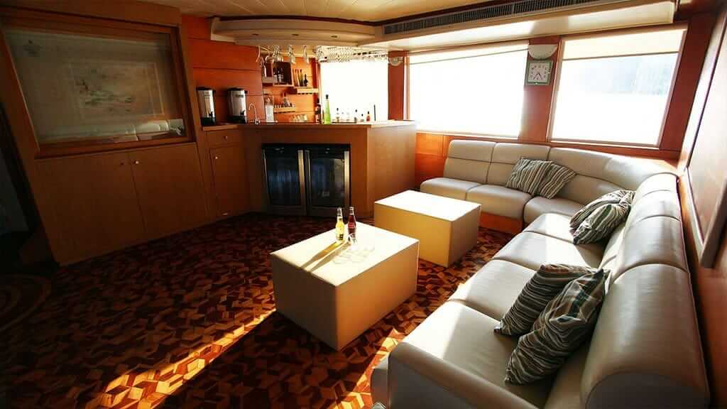 comfortabele lounge met leren bank aan boord van het Millenium Galapagos-jacht