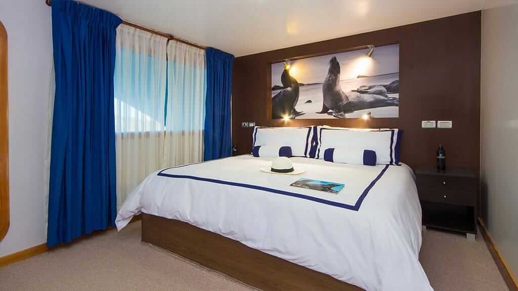 cabina de invitados con cama tamaño queen a bordo del catamarán Ocean Spray en Galápagos