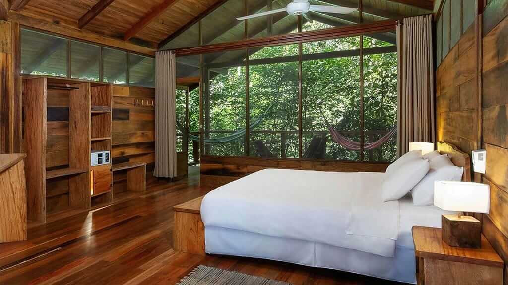 grote kamer met tweepersoonsbed met balkon en hangmatten bij Sacha Lodge Ecuador