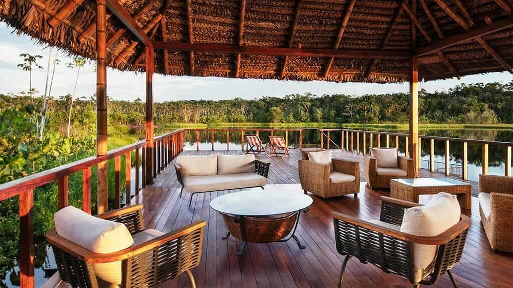 Sacha Lodge ecuador - open air lounge and coffee tables with balcony view over the amazon rainforest