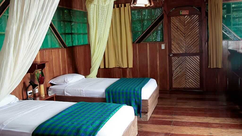 hut met twee eenpersoonsbedden en klamboes in de Tapir Lodge cuyabeno, ecuador
