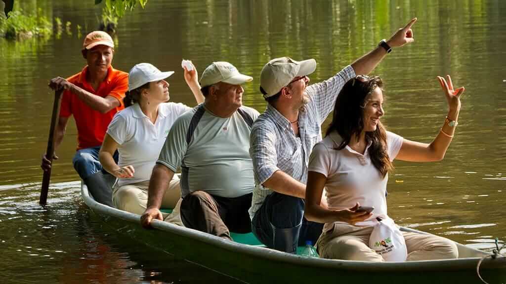 tourists spot jungle wildlife with guide from a canoe on a Yarina lodge tour