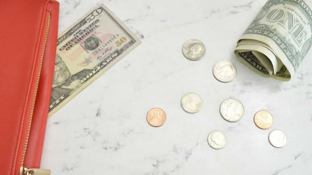 us dollar money and purse on a table