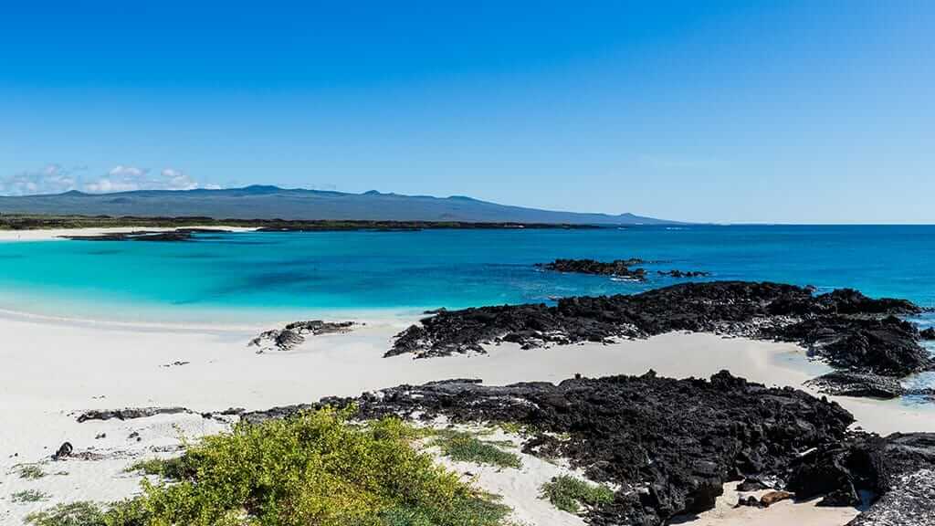 san cristobal galapagos landscape of white sand, black lava and turquoise waters
