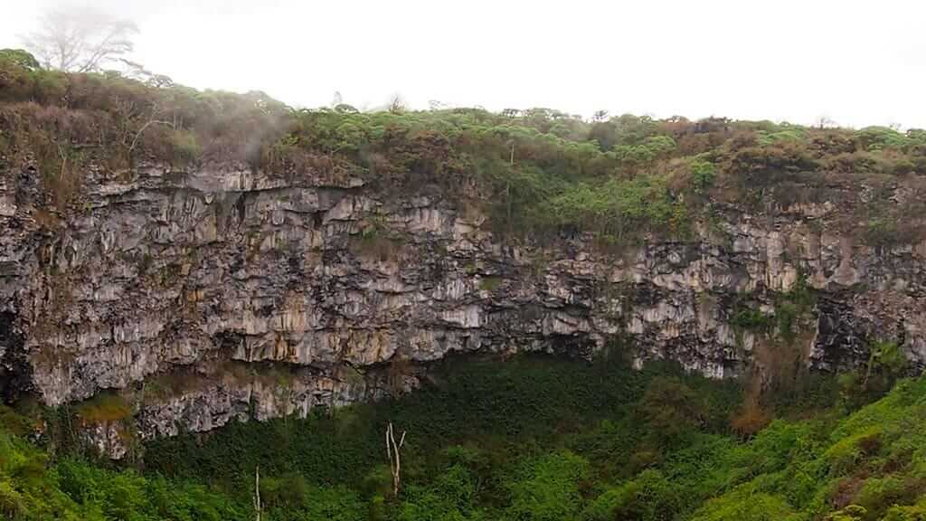 twin craters landscape of lava cliffs and forest at Galapagos