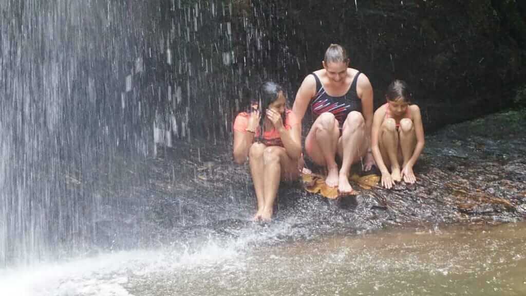family bathing under mashpi lodge waterfall