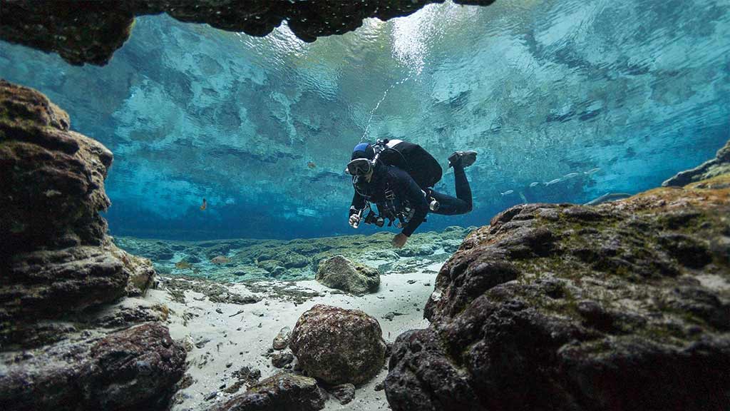 diver between rocks in the galapagos islands 