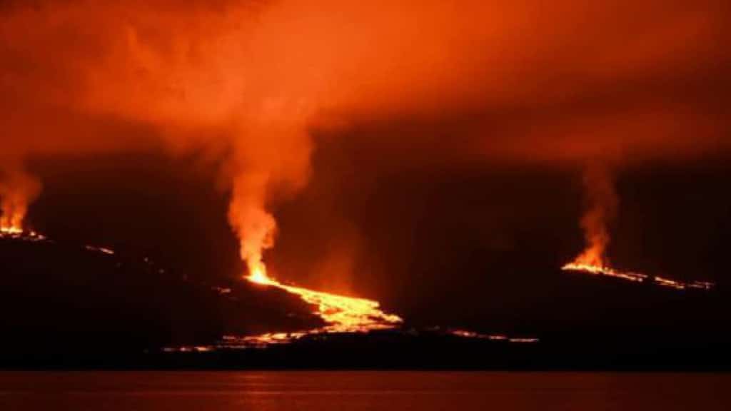 galapagos volcano sierra negra erupts with lava flowing to the sea