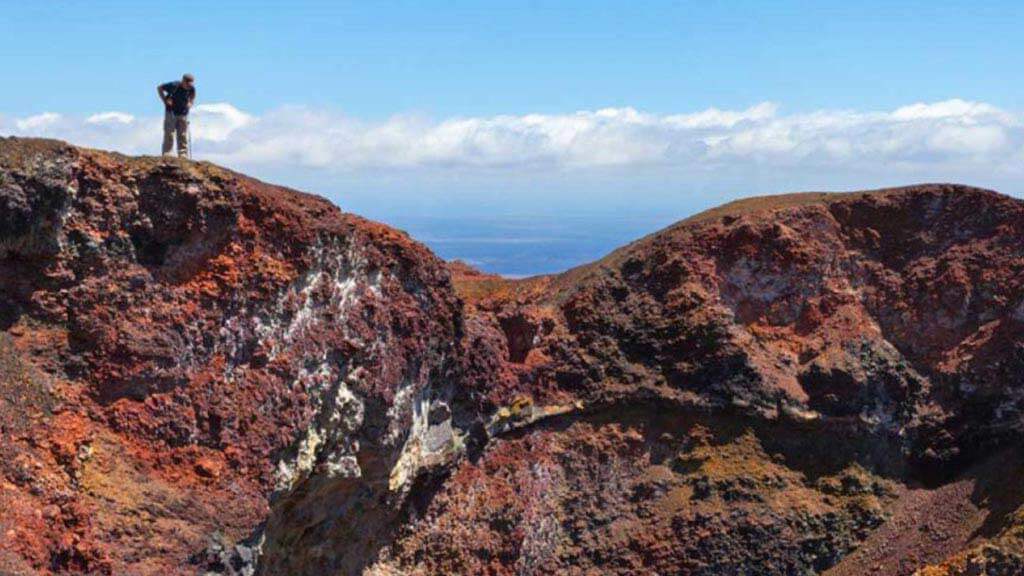 Een toerist tuurt naar Volcano Chico op het eiland Isabela in Galapagos