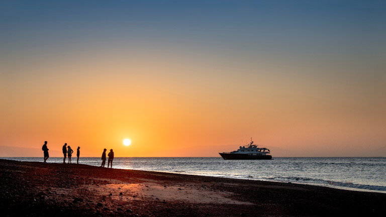 Group-of-passengers-at-sunset-walking-along-the-coast