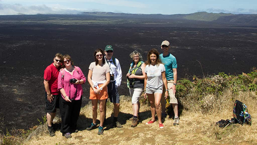 Groupe de touristes en face de l'immense cratère du volcan sierra negra isabela island galapagos