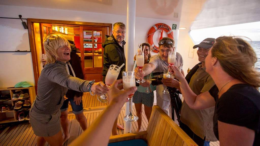 cheers tourists drinking champagne aboard passion-yacht-passengers-celebrating