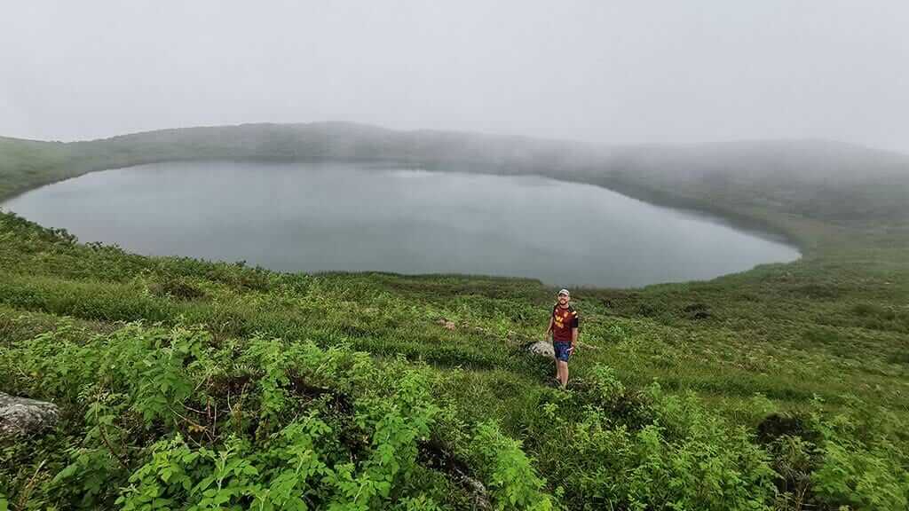 toerist poseren bij el junco lake san cristobal galapagos in de mist