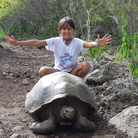 young happy gringo tourist with galapagos giant tortoise